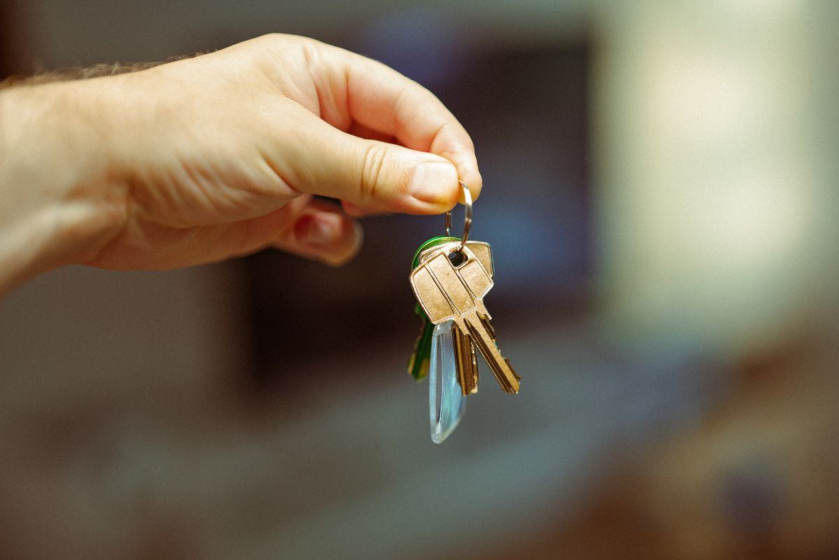 Hand holding a set of house keys, representing buying a home in Castaic, Santa Clarita
